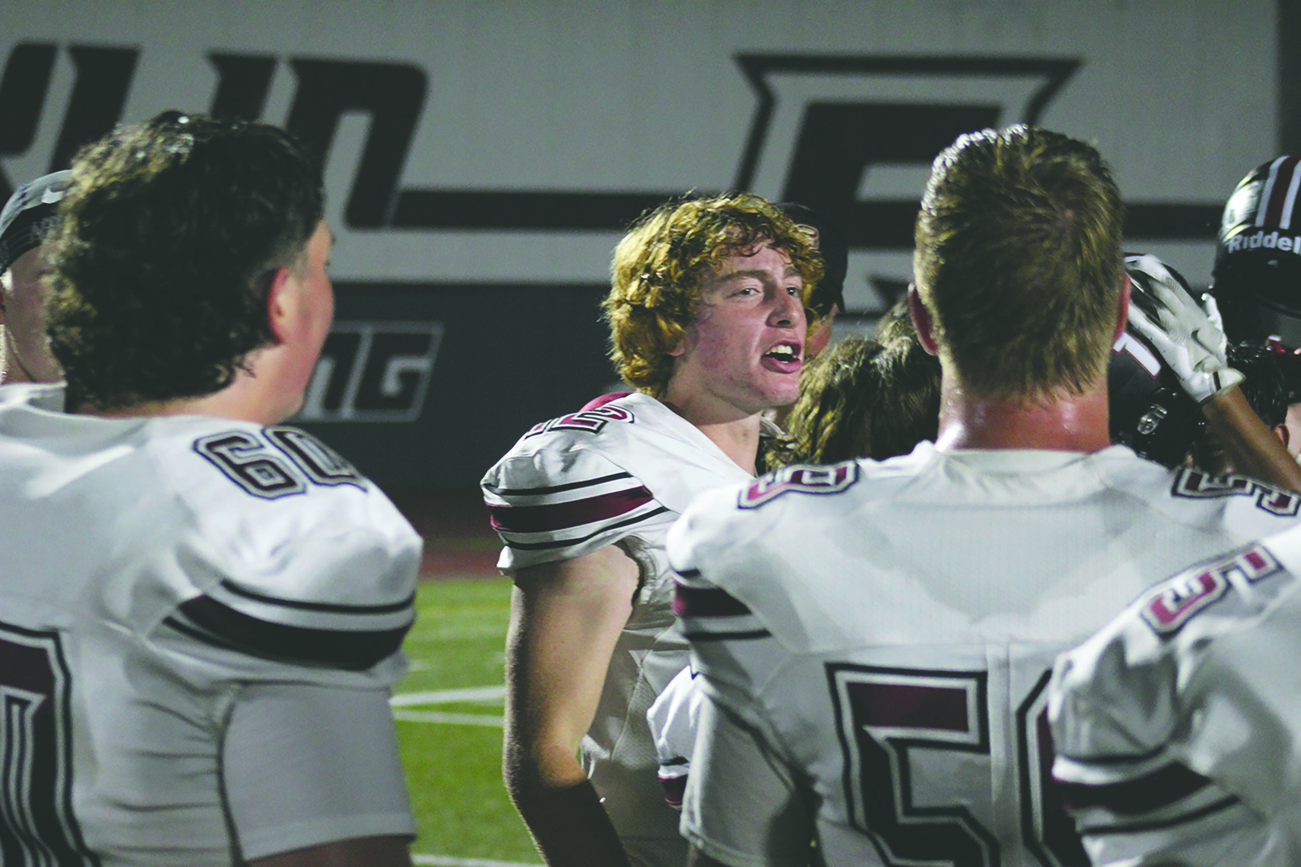 Athlete leads huddle at a football game