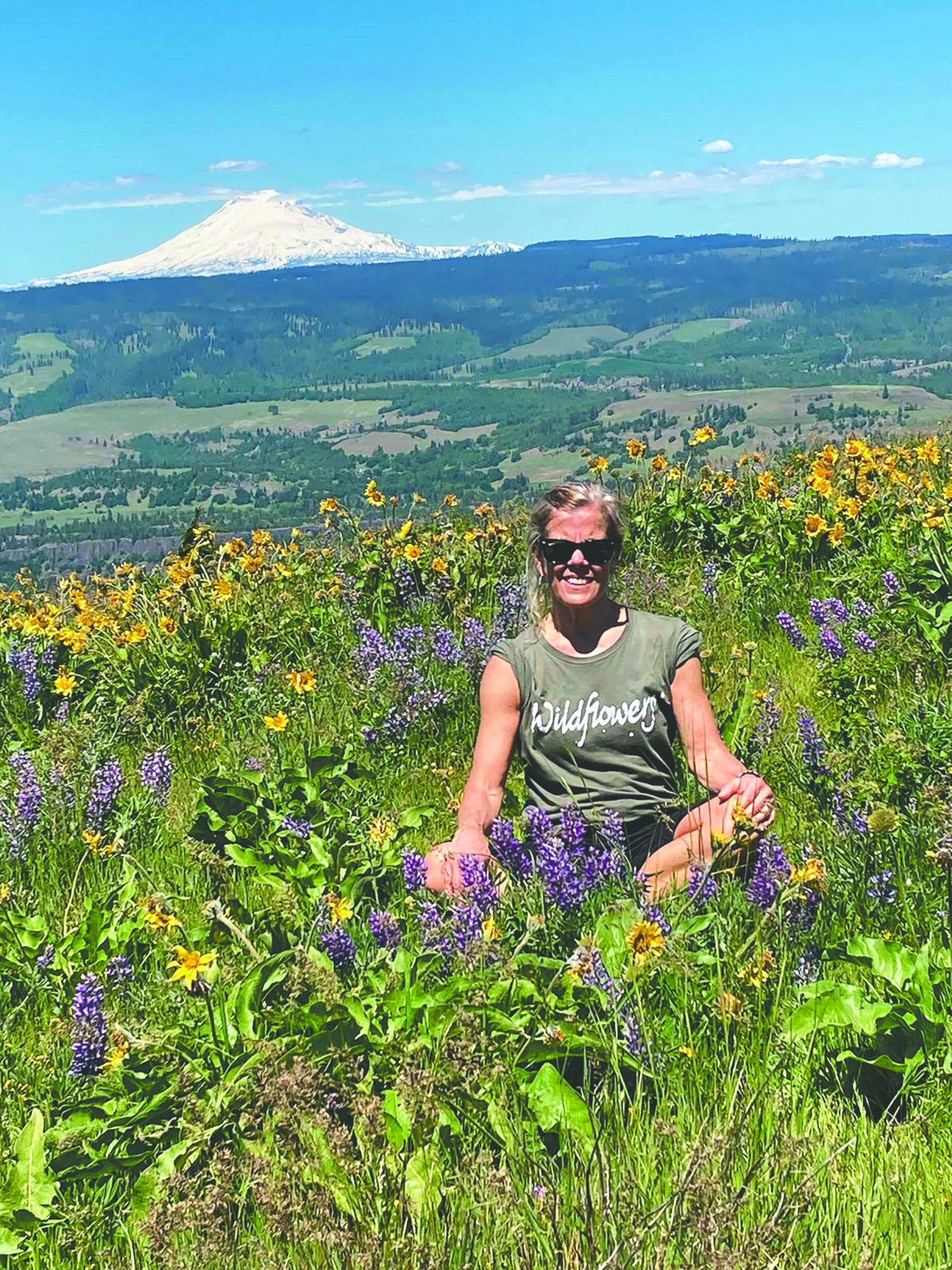 an instructor sits in a field of flowers