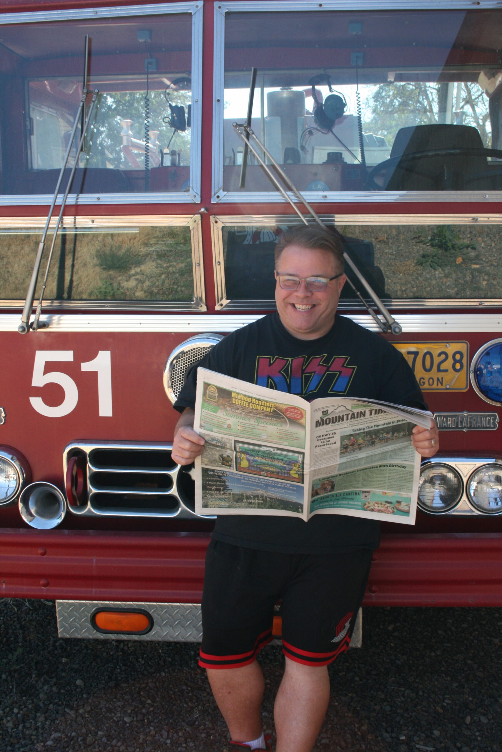 Matt leans agaist the front of a fire truck reading the mountain times