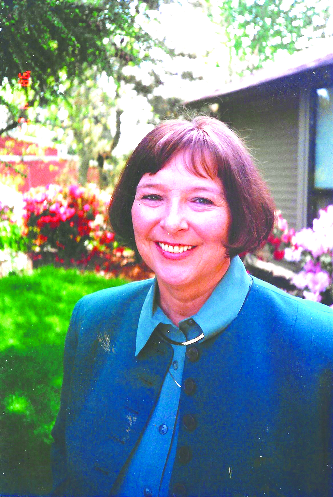 Maureen poses, smiling in her garden