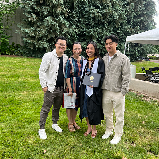 proud family poses with a girl in cap and gown