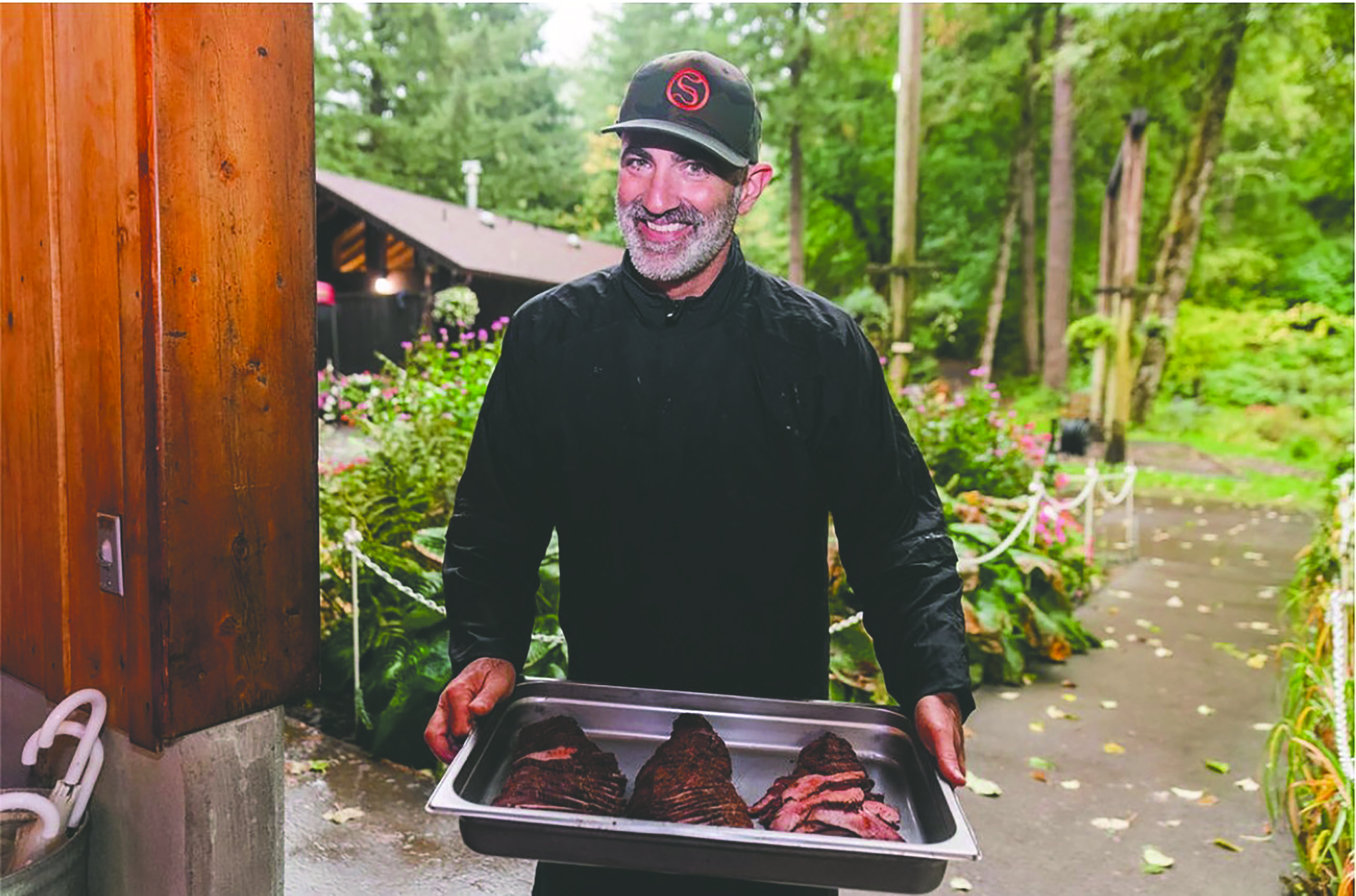 restaurant owner holds out a tray of fresh roast