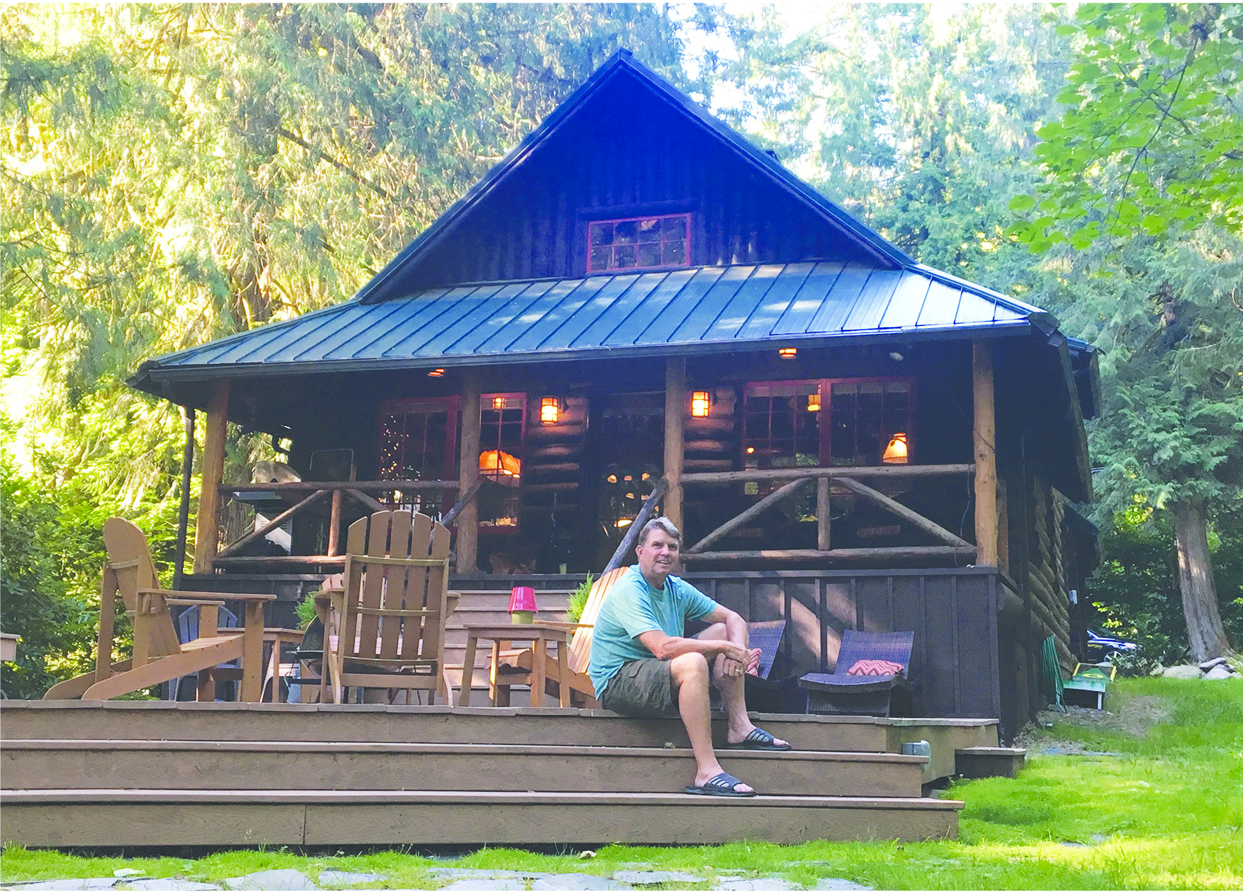 Steiner sits on the steps of the old cabin