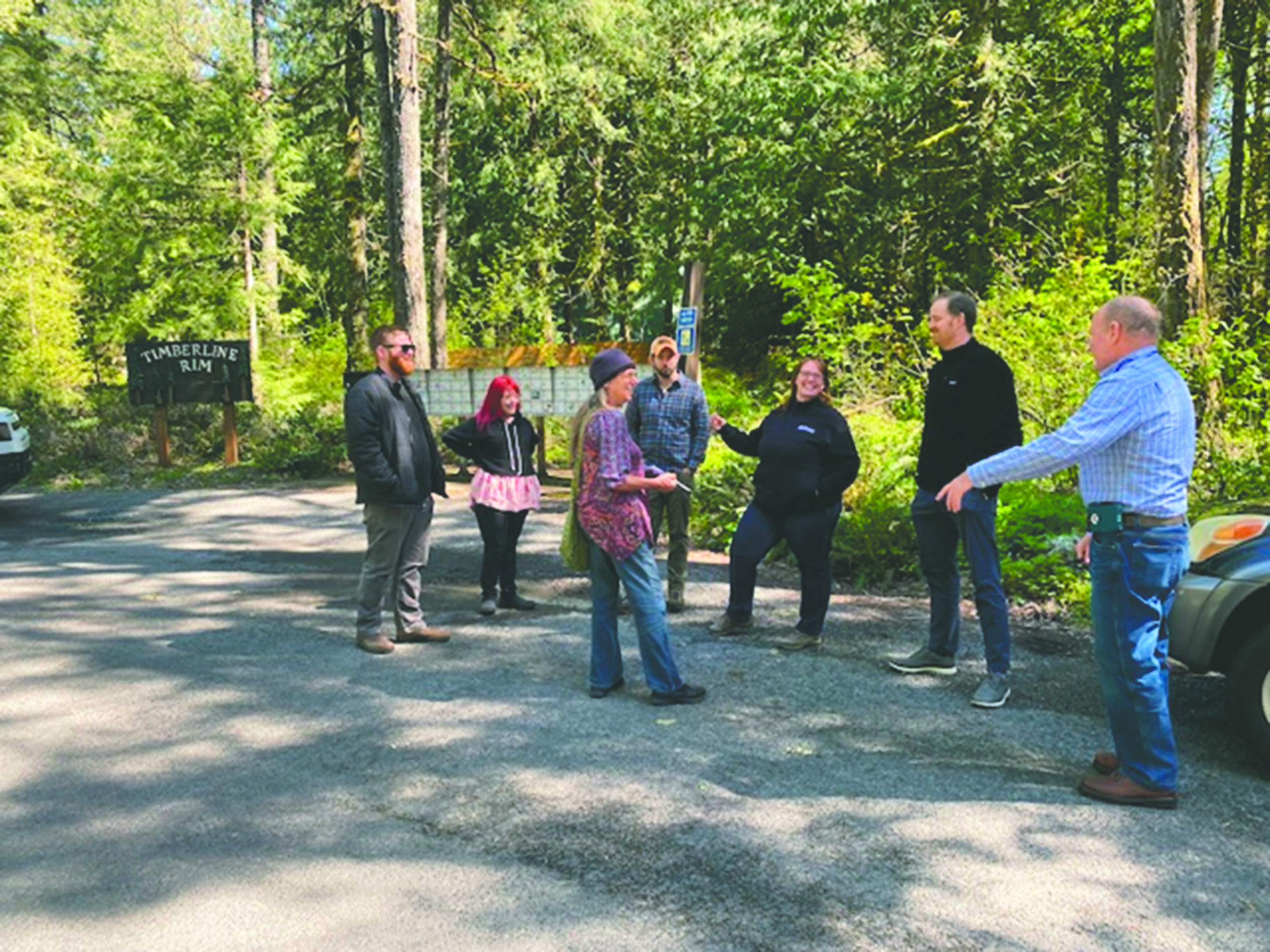 People gather and talk at a trail head