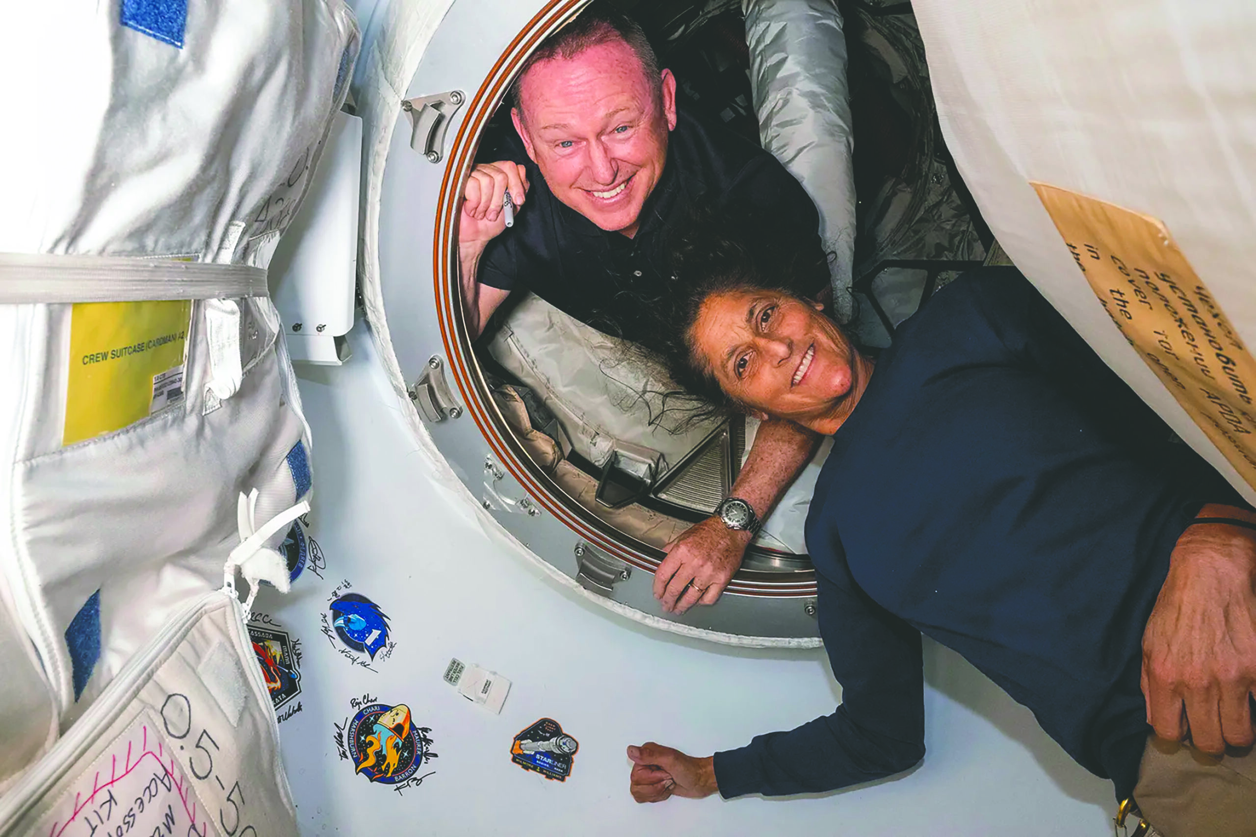 two astronauts floating in their capsule