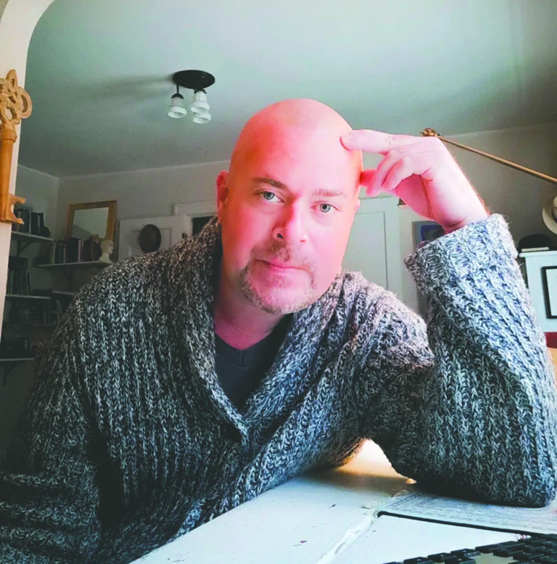 Acting teacher Jeffrey leans against his desk