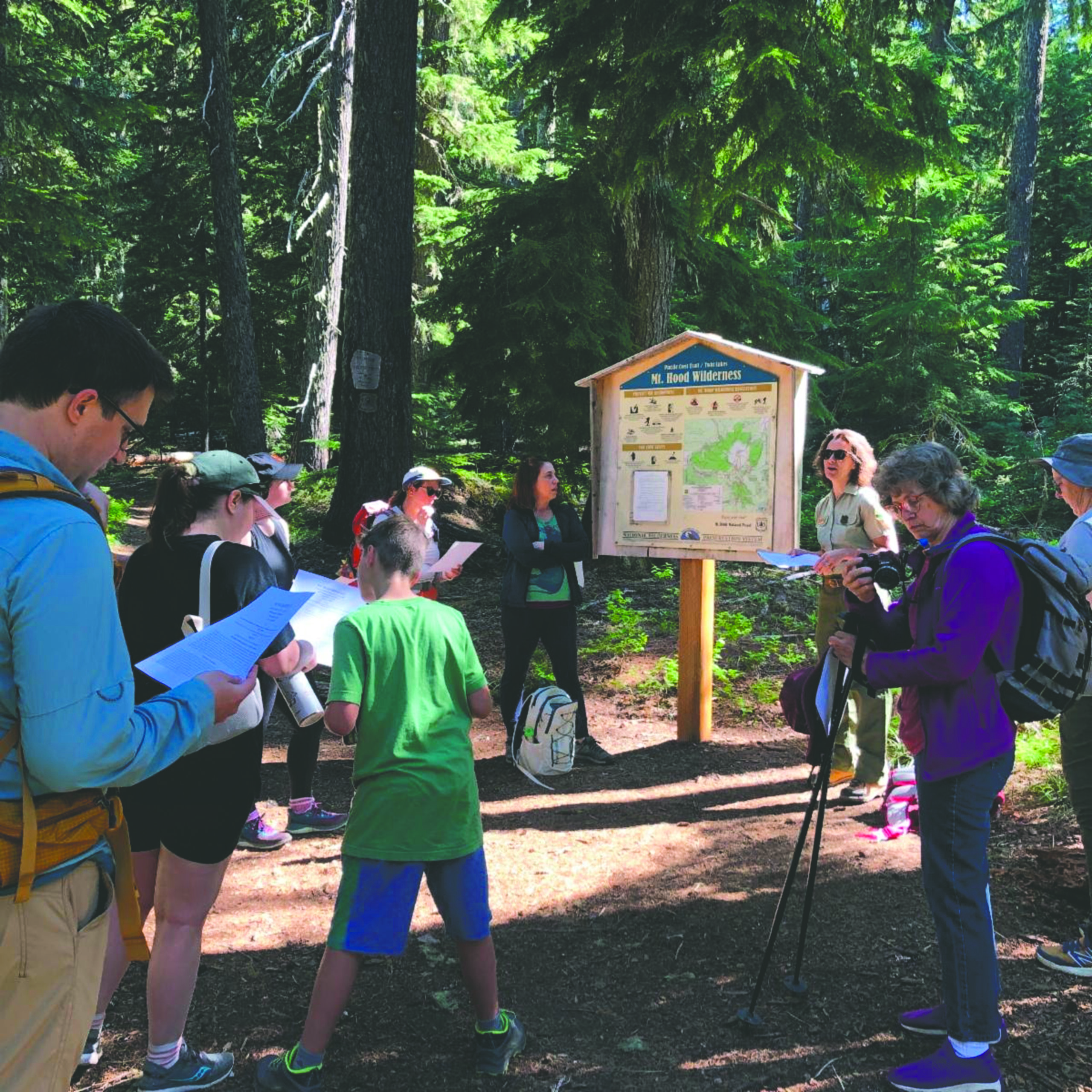 People gather and talk at a trail head