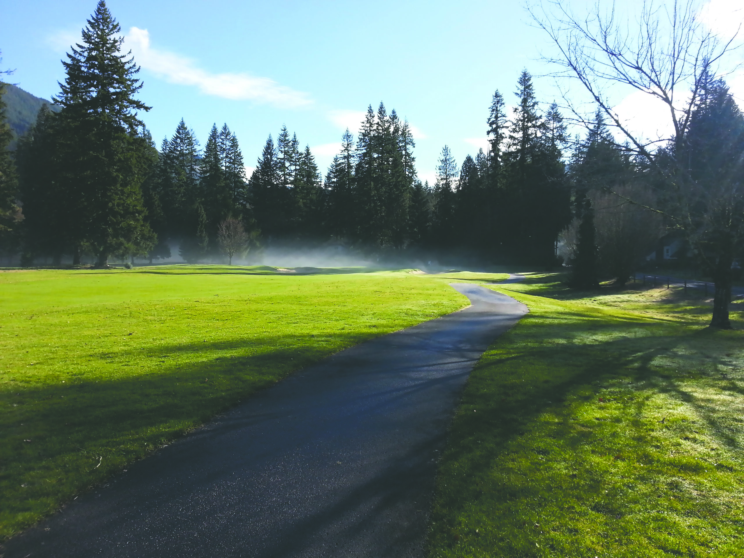 The golf course steams in the morning sun