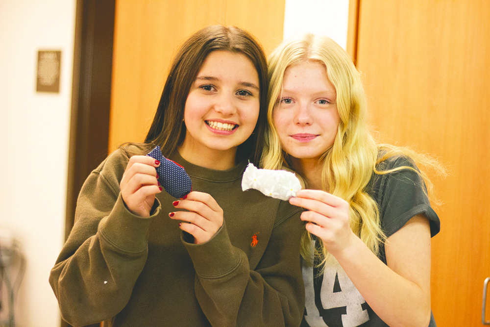 Two students holding their cat toys