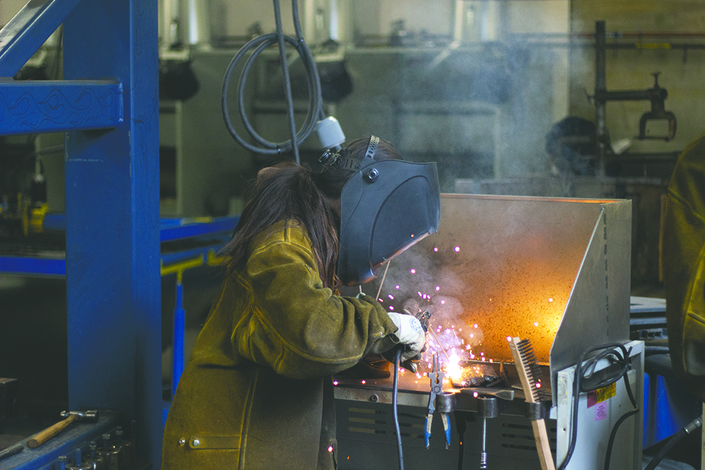 Student welds with sparks flying